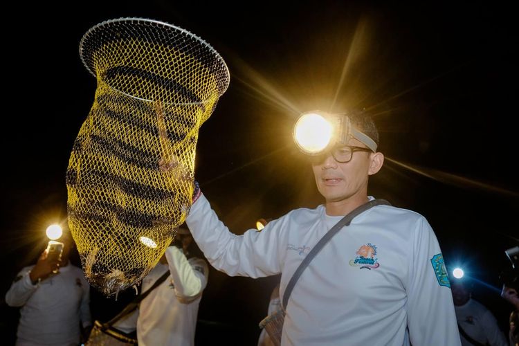 Menparekraf Sandiaga Uno mencoba salah satu aktivitas malam masyarakat sekitar Pantai Tanjung Pendam yaitu Nyulo, sebuah aktivitas mencari ikan, udang, dan kepiting pada saat event Pesona Belitung Beach Festival, Belitung, Jumat (2/6/2023).