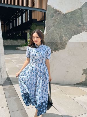 Model mengenakan cheongsam dengan motif biru floral.