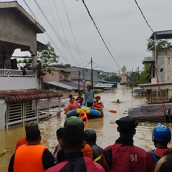 Puluhan warga menunggu keluarganya yang diselamatkan tim Search and Rescue (SAR) saat rumah mereka terendam banjir di Lingkungan XVIII, Kelurahan Kampung Baru, Kecamatan Medan Maimun, Kota Medan, Sumatera Utara, Kamis (27/11/2025).
