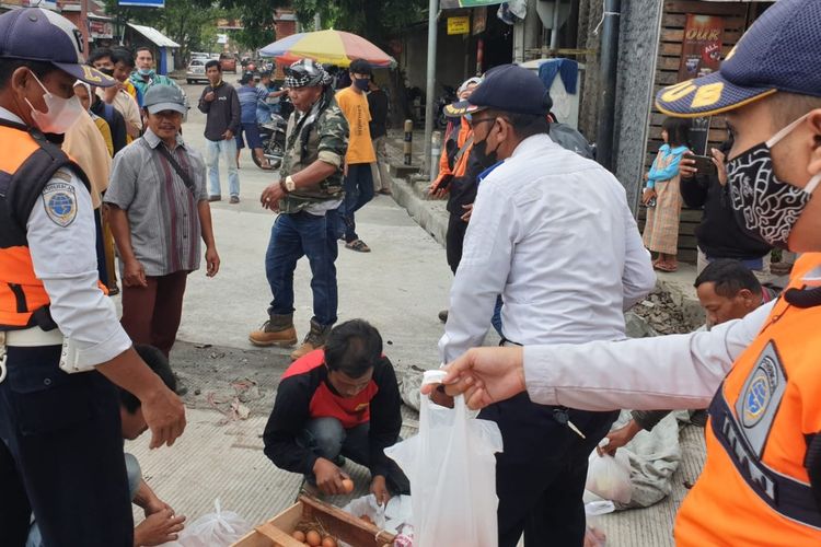 Seorang pengusaha terkenal Tasikmalaya Endang Abdul Malik (pakaian loreng) membagikan 3 ton telur gratis kepada masyarakat di pinggir jalan Singaparna pada Selasa (28/9/2021).