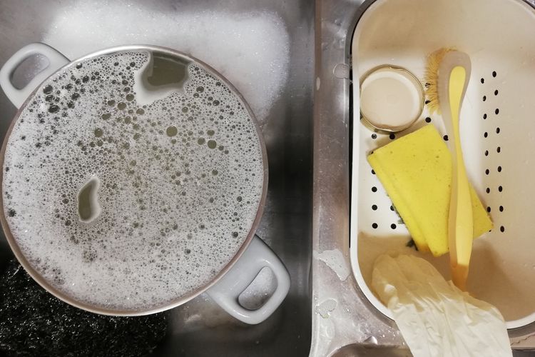 Ilustrasi cara membersihkan kerak panci gosong pakai air sabun hangat. 