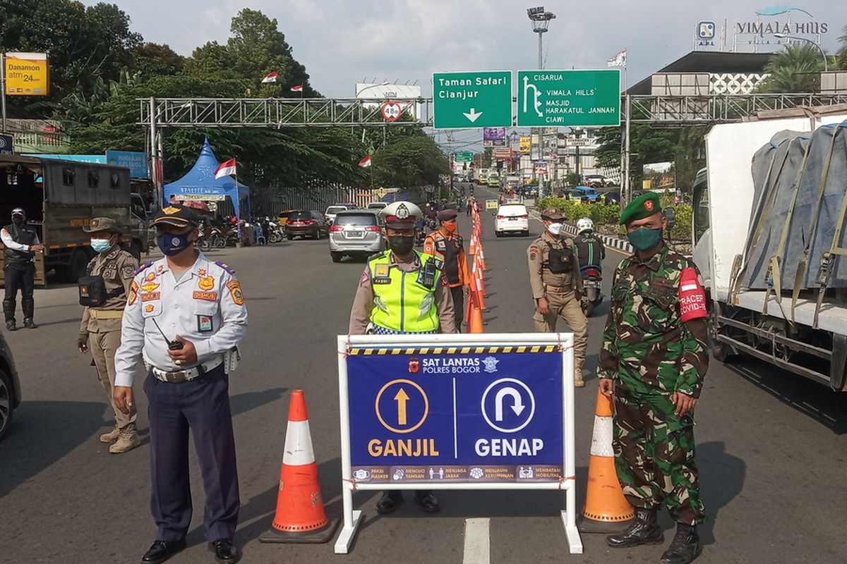 Sejumlah petugas gabungan Satgas Penanganan Covid-19 Kabupaten Bogor memeriksa kendaraan yang sesuai dengan aturan ganjil genap di Simpang Gadog, Kecamatan Ciawi, Kabupaten Bogor, Jawa Barat, Minggu (5/9/2021)