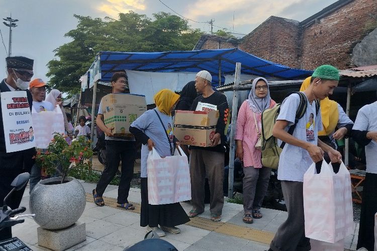 Relawan pendukung Anies Baswedan atau BroNies Tegal membagikan ratusan nasi kotak dan takjil untuk berbuka puasa warga di kawasan Alun-alun, Kota Tegal, Jawa Tengah, Minggu (9/4/2023). 