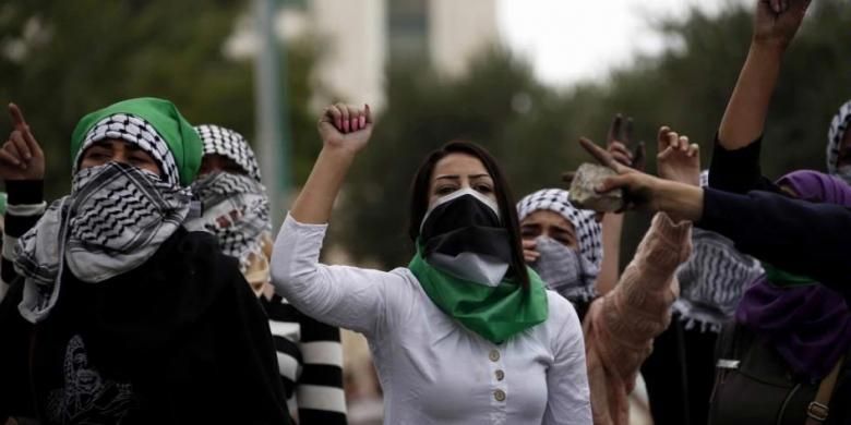 Perempuan Palestina memegang batu dan meneriakkan slogan saat bentrokan dengan tentara Israel di Beit El, Ramallah, Tepi Barat, 10 Oktober 2015.