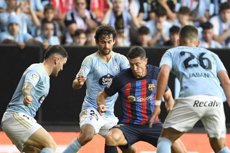 Penyerang Barcelona, Robert Lewandowski (tengah), berusaha melewati kawalan para pemain Celta Vigo dalam laga terakhir Liga Spanyol 2022-2023. Laga Celta Vigo vs Barcelona berlangsung di Stadion Balaidos pada Senin (5/6/2023) dini hari WIB.