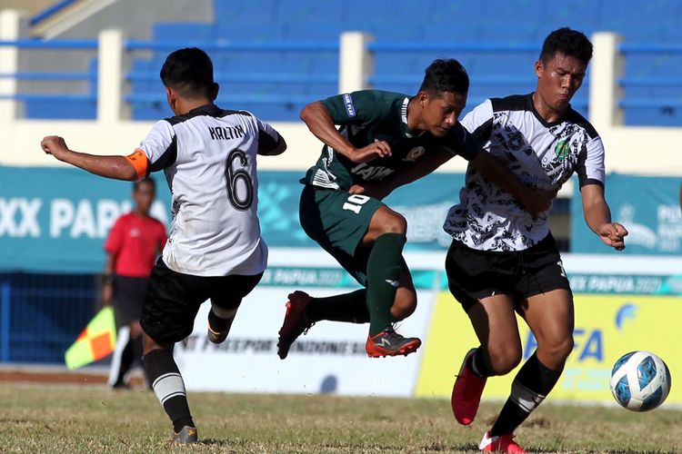 Pemain Jawa Timur Muhamad Faisol Yunus dijaga ketat pemain Kalimantan Timur saat babak 6 besar PON XX Papua 2021 yang berakhir dengan skor 5-1 di Stadion Barnabas Youwe Sentani, Kabupaten Jayapura, Jumat (8/10/2021) sore.