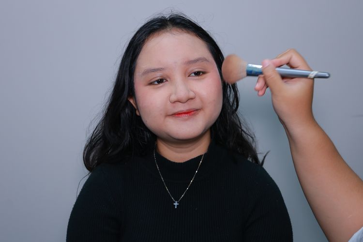Tambahkan blush on powder untuk hasil pipi merah merona.