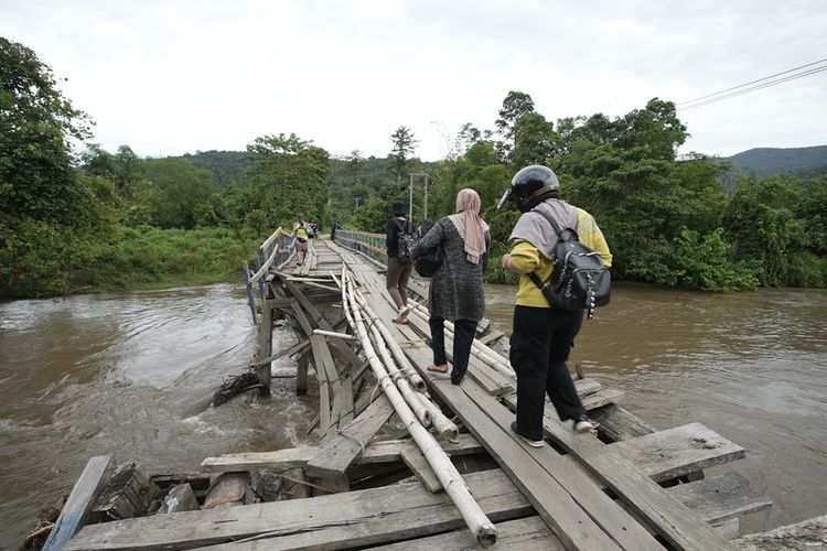 Masyarakat desa harus menyeberang dengan hati-hati di jembatan rusak di Kecamatan Ueesi, Kabupaten Kolaka Timur, Sulawesi Tenggara.
