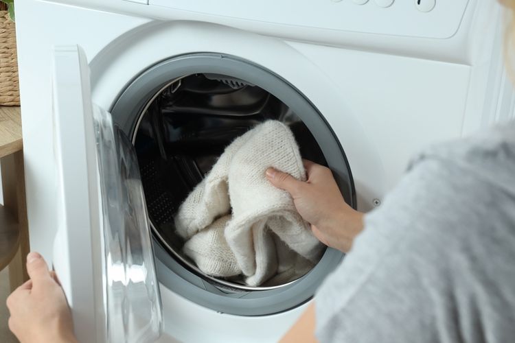 Ilustrasi mencuci pakaian di mesin cuci.