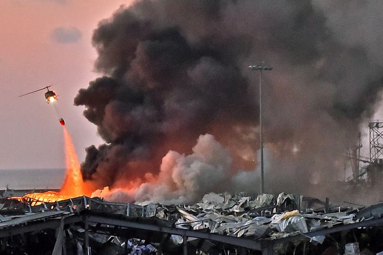 Sebuah helikopter berusaha memadamkan api dalam ledakan yang terjadi di pelabuhan Beirut, ibu kota Lebanon, pada 4 Agustus 2020.
