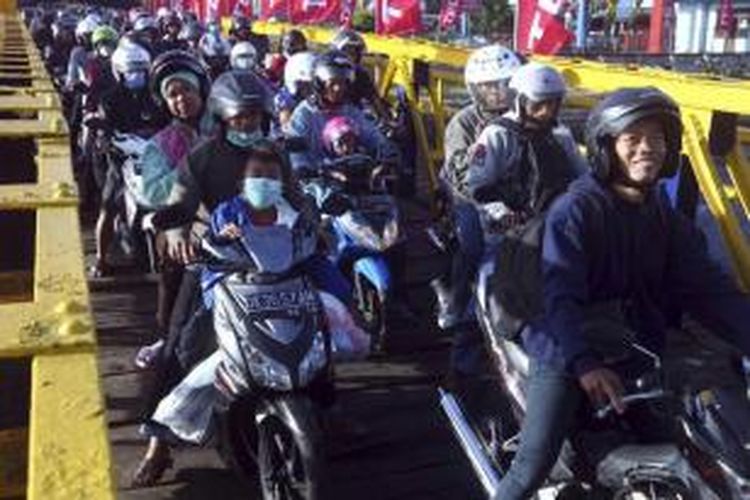 Pengendara motor mengantre saat akan memasuki kapal feri di Pelabuhan Gilimanuk, Bali, Senin, 13 Juli 2015. Mereka mudik ke kampung halaman untuk merayakan Hari Raya Idul Fitri.