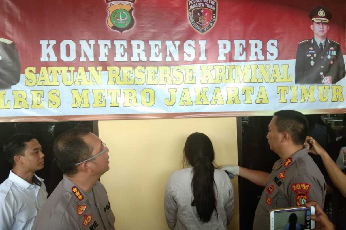 AS (tengah), wanita berusia 21 tahun, pelaku penyebar hoaks covid-19 di Pusat Grosir Cililitan (PGC), saat konferensi pers di Mapolres Metro Jakarta Timur, Rabu (18/3/2020).