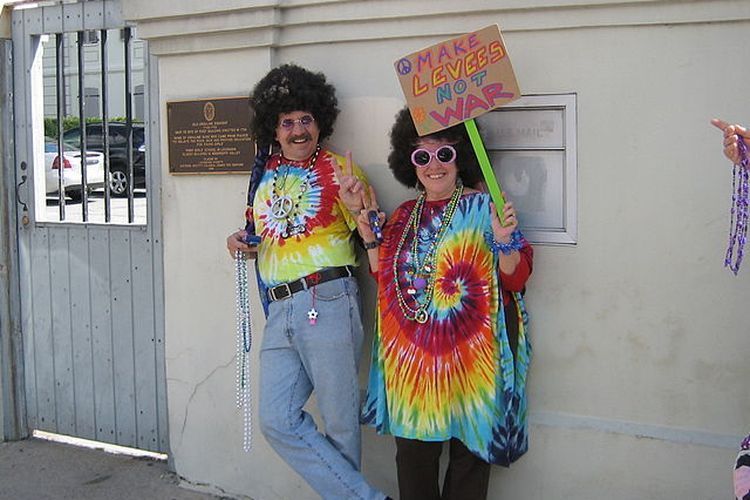 Seorang berdandan ala Hippie dengan memegang slogan Make love not war.