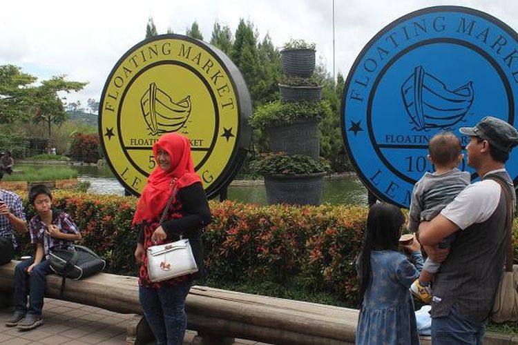 Pengunjung Floating Market Lembang berfoto di depan replika koin yang jadi mata uang Floating Market Lembang, Selasa (22/12/2015).