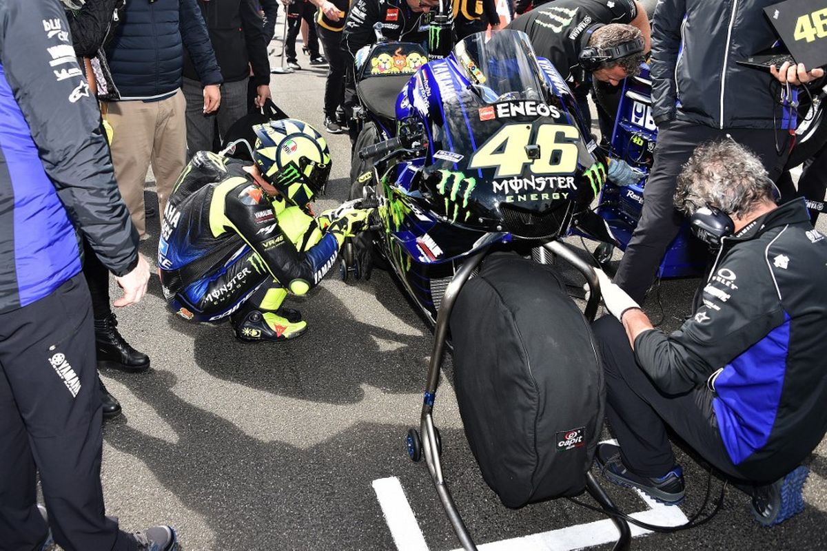 Kebiasaan yang dilakukan Valentino Rossi sebelum memulai balapan. (Photo by PETER PARKS / AFP) / -- IMAGE RESTRICTED TO EDITORIAL USE - STRICTLY NO COMMERCIAL USE --