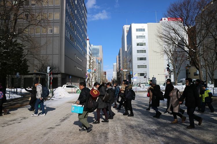 Turis menyeberang jalan untuk menikmati acara Sapporo Snow Festival ke-70 di Odori Park, Kota Sapporo, Prefektur Hokkaido, Jepang, Senin (11/2/2019). Sapporo Snow Festival merupakan acara musim dingin tahunan yang digelar di Kota Sapporo.
