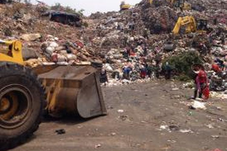 Pemungut terlihat mencari sampah yang bisa dijual disebelah alat berat di TPST Bantargebang pada Rabu (4/11).
