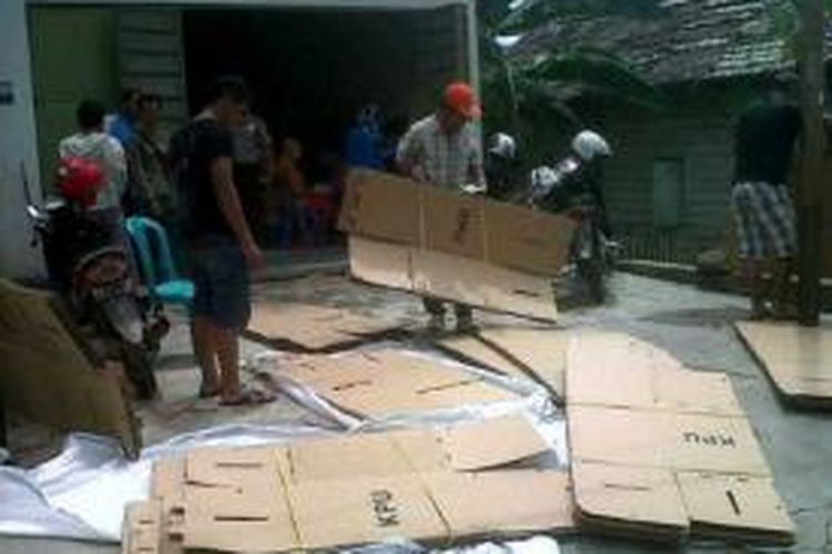 Staf KPU Bombana menjemur bilik dan kotak suara pemilu legislatif dari kardus, setelah atap gudang  penyimpan logistik bocor akibat hujan deras. 