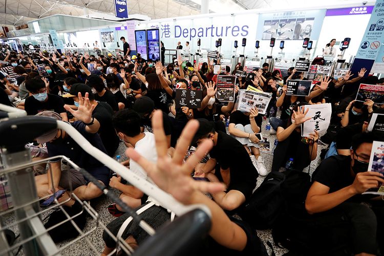 Pengunjuk rasa anti-pemerintah bereaksi setelah adanya pengumuman bahwa semua operasional bandara akan dihentikan karena demonstrasi di Bandara Hong Kong, China, Selasa (13/8/2019). Demo Hong Kong berlangsung intens dalam dua bulan terakhir dan berujung ricuh sejak UU Ekstradisi yang kontroversial mulai mendapat penolakan dari masyarakat.