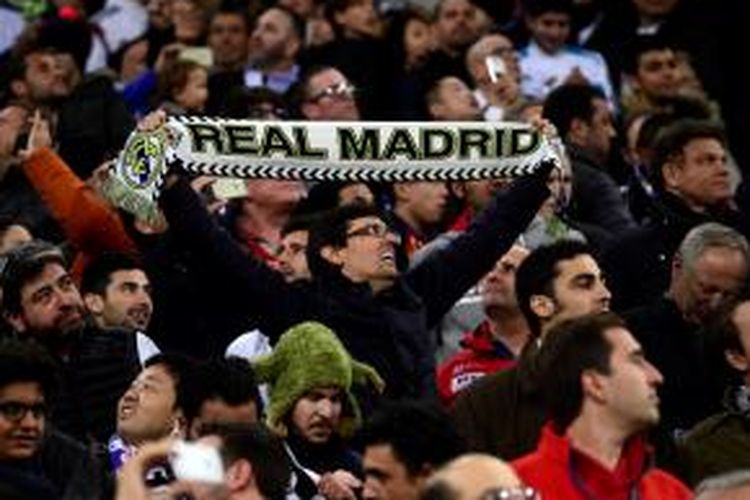 Suporter Madrid membentangkan scarf klub saat pertandingan melawan Barcelona di Stadion Santiago Bernabeu, Sabtu (21/11/2015).
