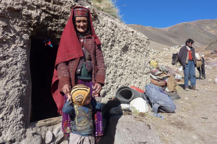 Foto ini diambil 10 Oktober 2017 menunjukkan suku Wakhi yang nomaden di Afghanistan. Sultan Belgium berdiri dengan cucunya di luar rumahnya, di Koridor Wakhan, Afghanistan. (AFP /Gohar Abbas)