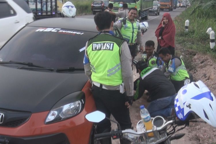 Personel polisi dari Satlantas Polres Ogan Ilir turun tangan membantu seorang wanita yang mengalami pecah di Jalintim Palembang-Ogan Ilir