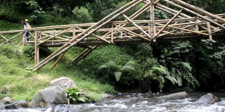 Pengunjung melintasi jembatan kayu di kawasan wisata Coban Pelangi, Kecamatan Poncokusumo, Kabupaten Malang, Jawa Timur, Senin (19/9/2016). Kabupaten Malang memiliki banyak air terjun atau coban, yang menjadi salah satu andalan sektor wisata di sana selain pantai.