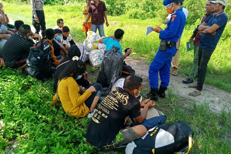 Sebanyak 21 tenaga kerja Indonesia (TKI) ilegal dari Malaysia diamankan petugas di Pantai Kambilik, Kabupaten Asahan pada Rabu (27/5/2020). Mereka menyeberang dari Sikincan, Malaysia ke Indonesia menggunakan kapal tongkang melalui jalurtikus