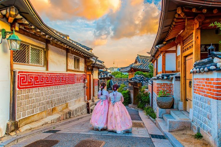 Ilustrasi Korea Selatan - Dua orang wisatawan sedang menggunakan hanbok dan berjalan-jalan di Bukchon Hanok Village, Korea Selatan.