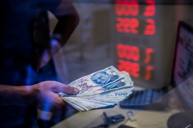 Petugas menunjukkan uang Lira di kantor penukaran uang di Istanbul, 13 Agustus 2018. Dirundung krisis ekonomi, nilai tukar mata uang Turki lira merosot tajam. Hingga Jumat (10/8/2018) lalu, posisi lira anjlok 15,88 persen ke level 6,4323 per dollar Amerika Serikat (AS).