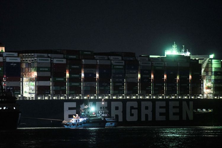 Foto pada Sabtu (27/3/2021) memperlihatkan kapal tunda berusaha menggerakkan kapal Ever Given (dioperasikan oleh Evergreen Marine Corp) asal Taiwan, yang terjebak dan membuat Terusan Suez macet sejak Selasa (23/3/2021) di kedua sisi.
