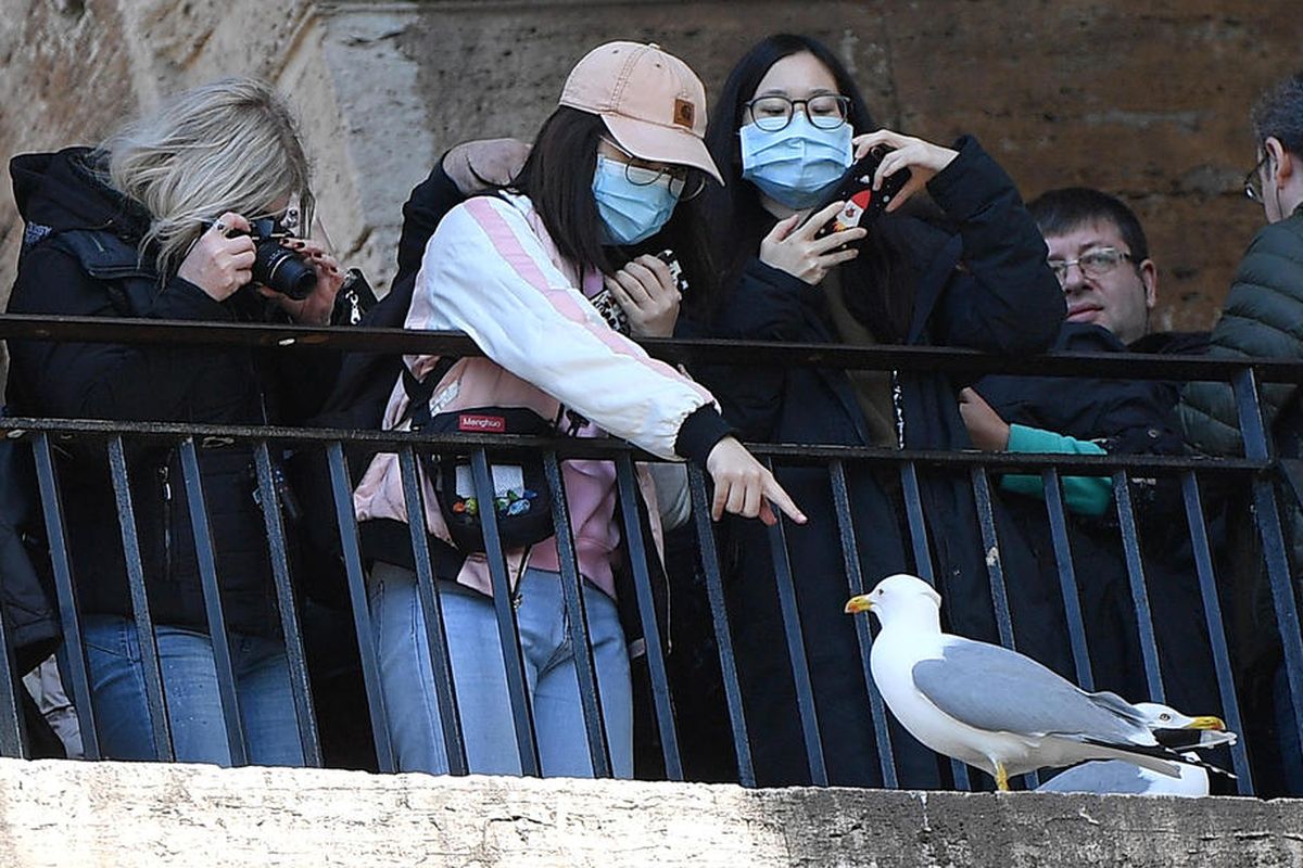 Turis yang memakai masker pelindung mengunjungi Roma, Italia, 26 Februari 2020. Menurut statistik resmi terbaru, lebih dari 370 orang telah terinfeksi oleh virus corona Wuhan, dan setidaknya 12 orang meninggal karena COVID-19 di negara Mediterania sejauh ini. EPA-EFE/ETTORE FERRARI