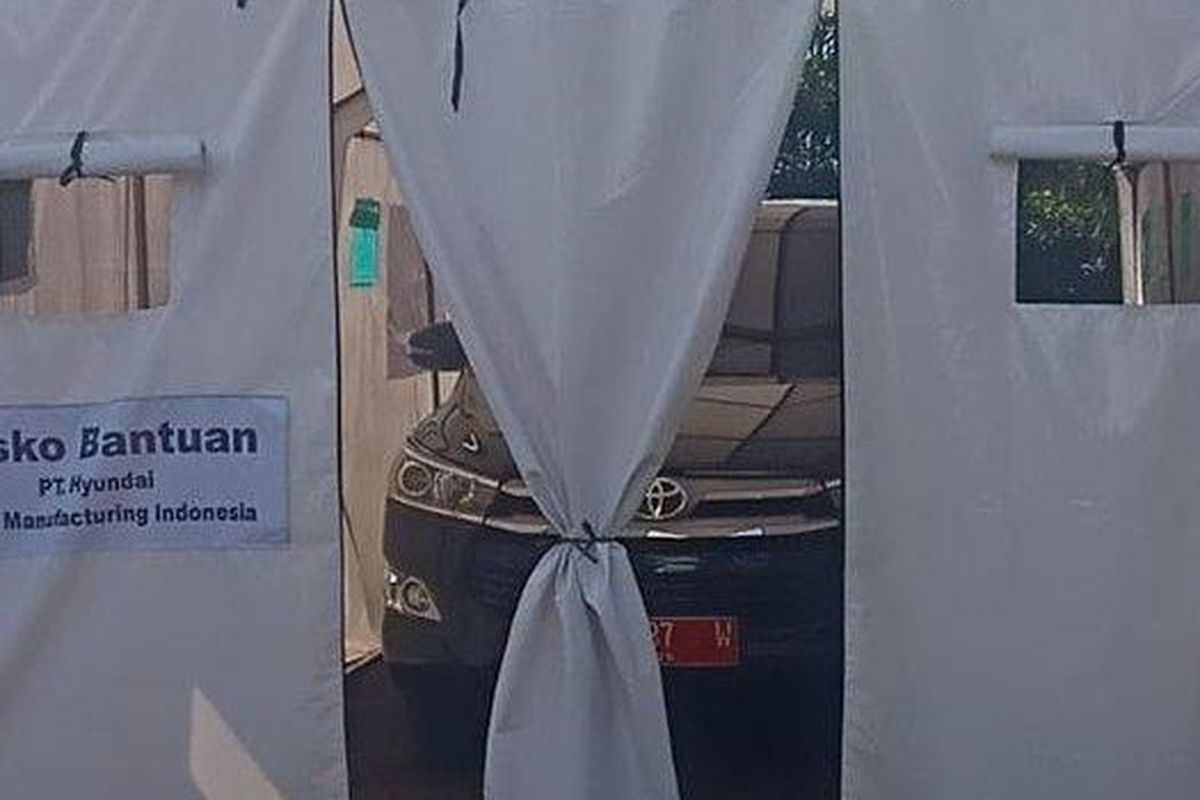 Mobil berpelat merah diparkir di tenda bantuan untuk korban bencana alam Cianjur. 