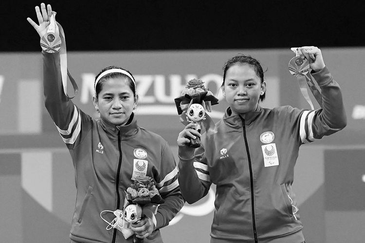 Pebulu tangkis ganda putri Indonesia Oktila Leani Ratri (kiri) dan Sadiyah Khalimatus berpose dengan medali emas saat prosesi penyerahan medali bulu tangkis nomor ganda putri kategori SL3-SU5 pada Paralimpiade Tokyo 2020 di Yoyogi National Stadium, Tokyo, Jepang, Sabtu (4/9/2021). Leani/Khalimatus meraih medali emas setelah mengalahkan wakil China Cheng He Fang-Ma Huihui dengan skor 21-18 dan 21-12.