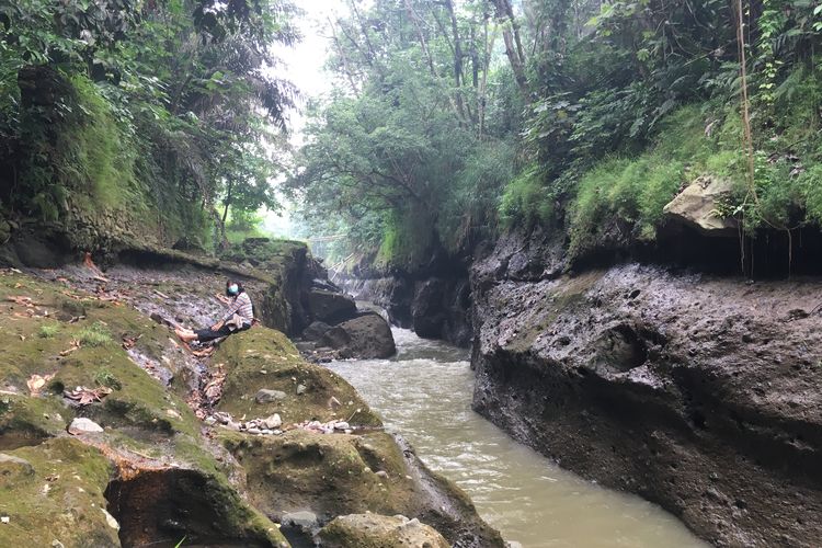 Para wisatawan sedang berjalan memasuki kawasan hutan untuk menuju ke salah satu titik Sungai Ciliwung yang memiliki pesona indah, lengkap dengan pepohona rindang, serta rerumputan dan semak belukar yang masih hijau dan asri, Kota Bogor, Senin (24/5/2021).