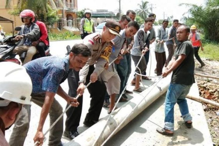 Kapolres Aceh Utara AKBP Ian Rizkian memindahkan tiang listrik yang patah ditabrak pemudik di lintas nasional Medan-Banda Aceh tepatnya Desa Geumata, Kecamatan Lhoksukon, Kabupaten Aceh Utara, Sabtu (16/6/2018)