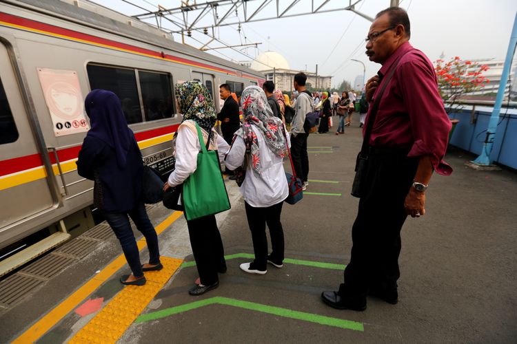 Sejumlah penumpang kereta listrik (KRL) Jabodetabek menunggu di garis batas antrean berwarna hijau di Stasiun Juanda, Jakarta Pusat, Rabu (9/8/2017). Garis batas antrean ini dibuat agar arus keluar masuk penumpang lebih teratur dan diharapkan dapat menghindari aksi saling mendorong sesama penumpang KRL.