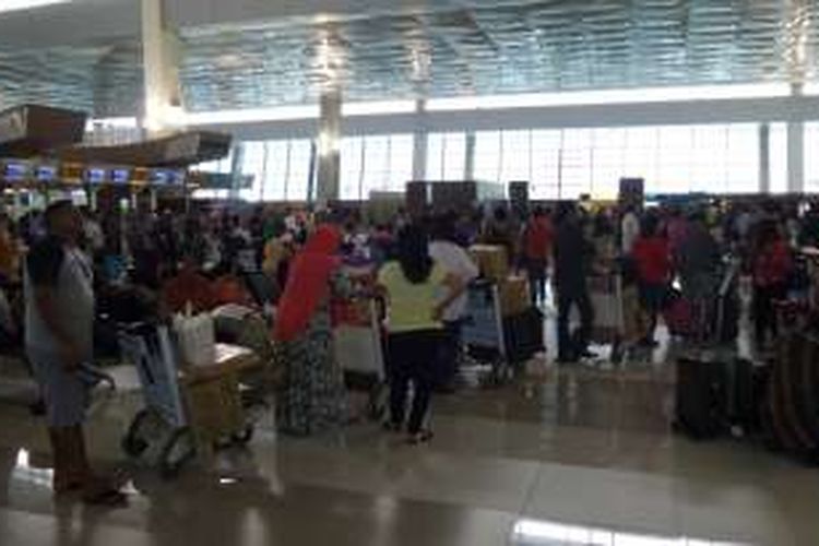 Antrean penumpang mengular di counter check in Terminal 3 New Bandara Soekarno-Hatta, Jumat (12/8/2016). Sistem check in sempat down sehingga proses ticketing dilakukan dengan manual dan memakan waktu cukup lama.