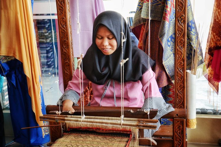 WEST SUMATRA, Indonesia - DECEMBER 15, 2018 : Female workers are preparing a songket at a fabrication center in Pandai Sikek, West Sumatra. Songket is considered luxurious traditional fabric.