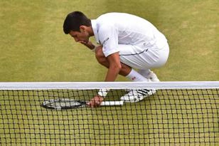 Petenis Serbia, Novak Djokovic, mencium lapangan setelah mengalahkan petenis Afrika Selatan, Kevin Anderson, pada babak keempat Wimbledon di All England Tennis Club, London, Selasa (7/7/2015). Djokovic menang 6-7 (8), 6-7(8), 6-1, 6-4, 7-5.