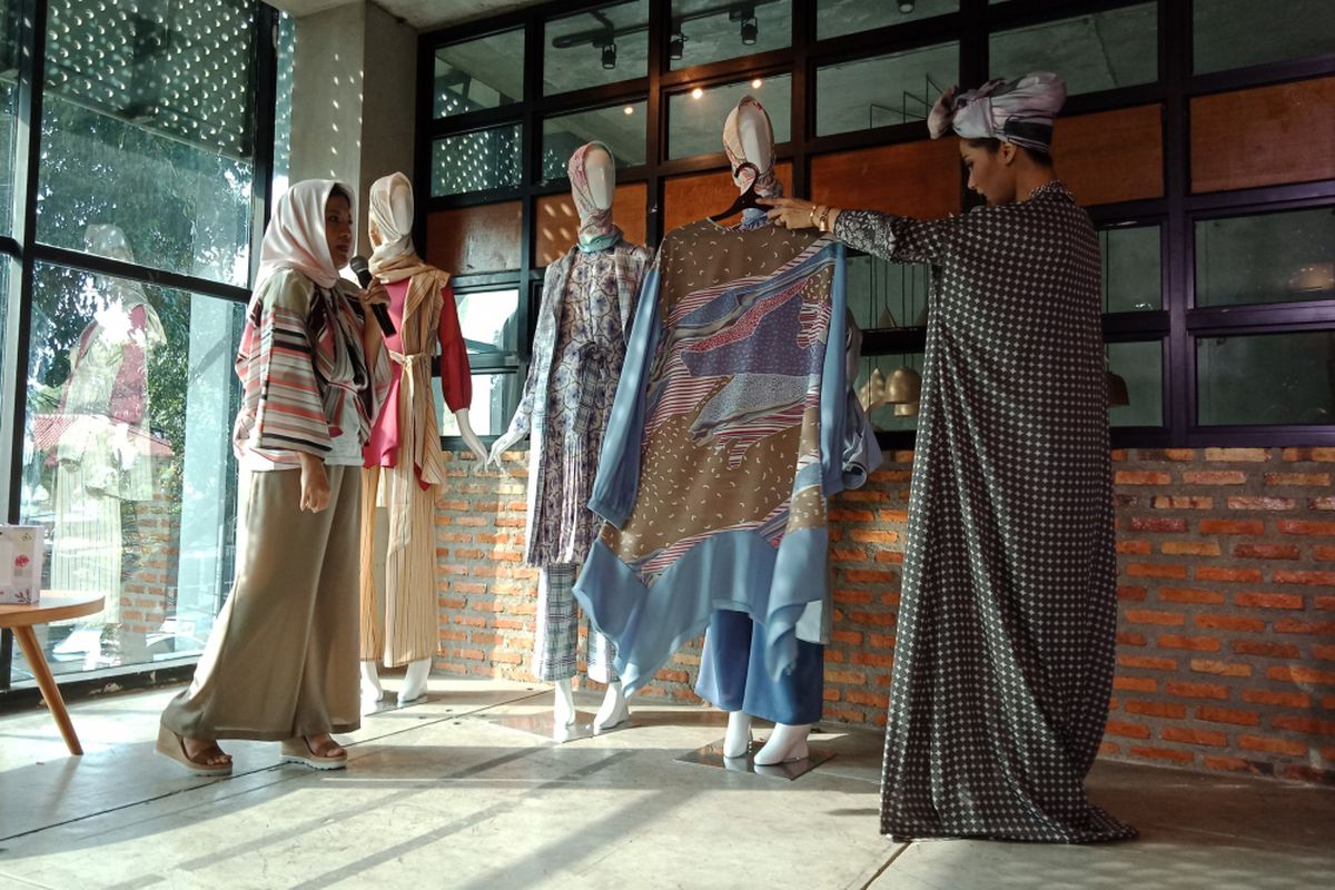 Fashion stylist Quartini Sari (kiri) saat membahas koleksi ALLEA Itang Yunasz di Conclave, Jakarta Selatan, Rabu (14/3/2018). Salah satu yang dibahas adalah desain yang merepresentasikan keretakan, yakni pakaian yang sedang dipegang oleh Presenter Nadya Mulya (kanan). 