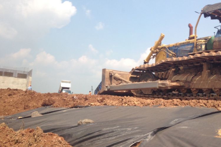 Sebuah traktor meratakan lahan yang nantinya akan difungsikan sebagai Jalan Tol Pemalang-Batang, Senin (22/5/2017).