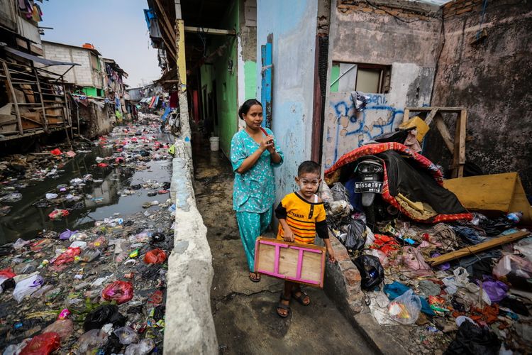 Warga berjalan di dekat kali yang dipenuhi sampah di Jln. Jati Bunder, Kel. Kebon Melati, Kec. Tanah Abang, Jakarta Pusat , Selasa (5/9/2017). Pemprov DKI Jakarta bersama dengan PemerintaPemprov DKI Jakarta bersama dengan Pemerintah Pusat akan menata kawasan kumuh melalui pencanangan program 100-0-100 yang dicanangkan Kementerian Pekerjaan umum dan Perumahan Rakyat dengan target Jakarta bebas dari kawasan kumuh pada tahun 2019. 