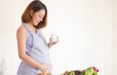 Ilustrasi ibu hamil menjaga kehamilan dengan mengonsumsi makanan dan minuman bernutrisi. 