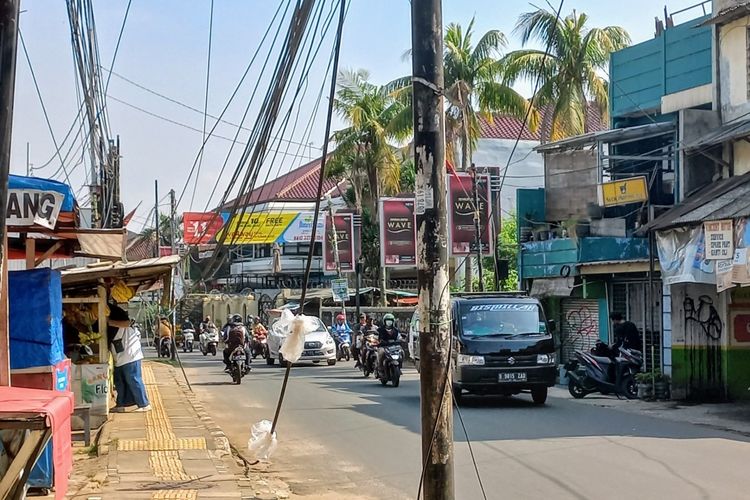 Kabel menjuntai dan tiang berdiri di badan Jalan WR Supratman, Ciputat Timur, Tangerang Selatan, Rabu (6/10/2021).