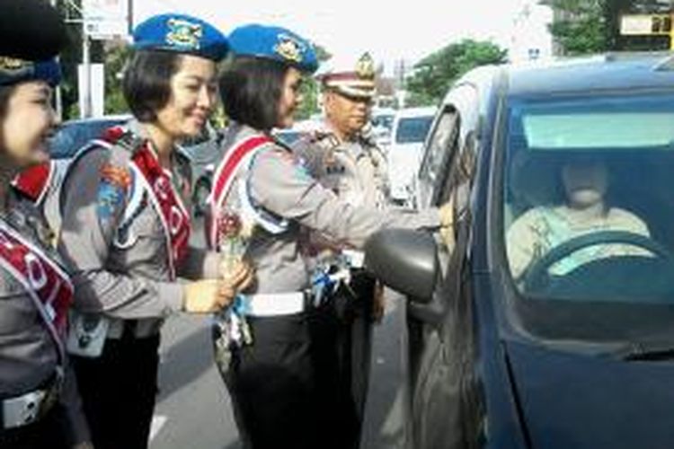 Polwan dijajaran Polrestabes Makassar membagi-bagikan bunga kepada pengguna jalan Ahmad Yani setelah putusan Praperadilan dimenangkan oleh Komjen Budi Gunawan, Selasa (17/2/2015) pagi.