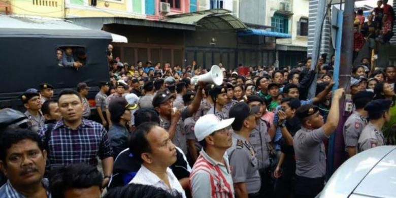 Ratusan warga menyaksikan penggeledahan di rumah tersangka Syamsul yang dituduh melakukan penganiayaan dan pembunuhan PRT di Medan. 