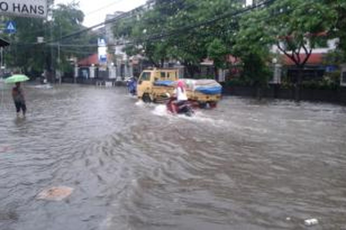 Banjir yang menggenangi Jalan Bendungan Hilir Raya, tepatnya di depan RS Mintoharjo, Jakarta Pusat, Sabtu (22/2/2014). Genangan air muncul pasca hujan deras yang mengguyur kawasan tersebut selama sekitar satu jam.