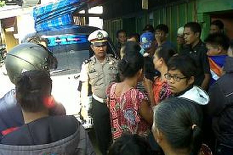 Seorang polisi di Kabupaten Bone, Sulawesi Selatan berupaya menenangkan warga yang mengamuk lantaran tidak terima lapak dagangannya ditertibkan oleh polisi pamong praja (Pol PP). Senin, (18/11/2013).