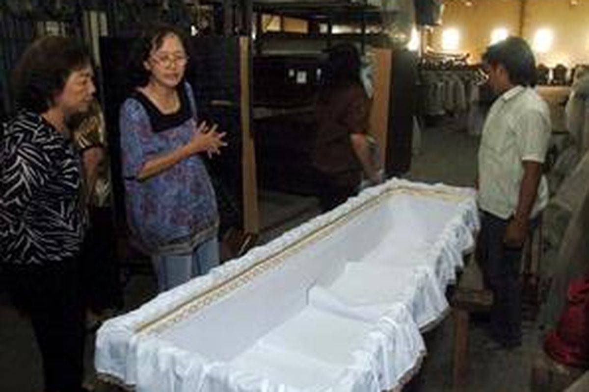 Para relawan yang mewakili keluarga, menyiapkan peti mati untuk Sumiarsih dan anaknya Sugeng di Surabaya, Jawa Timur, Jumat (18/7).